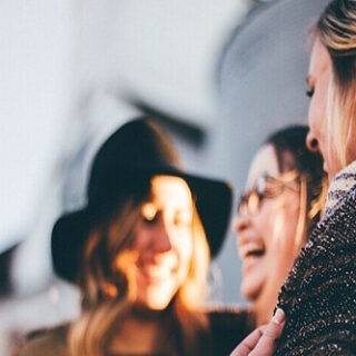 a group of women laughing together all with different body types