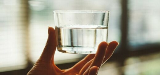 water in a glass being held up to symbolize hydration